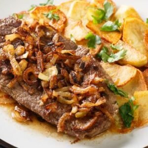 Zwiebelrostbraten de boeuf rôti avec des oignons et des pommes de terre frites Bratkartoffeln